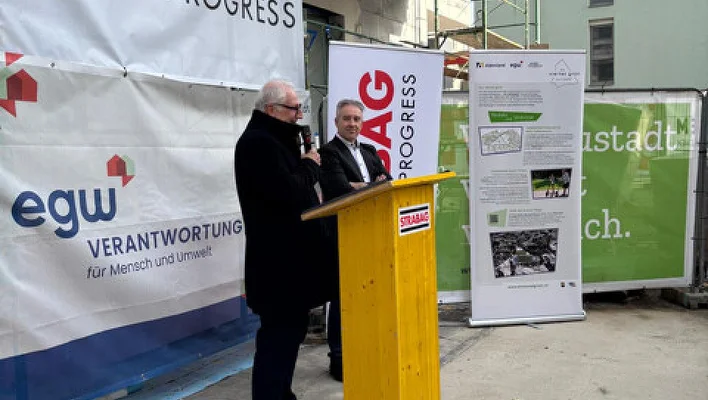 2 Personen mit Rednerpult und Transparenten