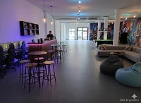 Gamecenter mit Laptops, Billardtisch, Sitzgelegenheit und Stehtischen