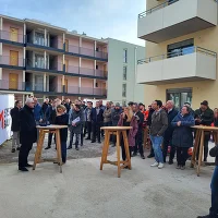 Blick auf die Baustelle mit Personen und Stehtischen