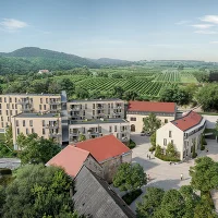 Dorfplatz mit Kirche, bestehende Häusern, Wohnhausanlage, Brücke, Bäumen und Blick ins Grüne