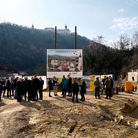 Menschenmenge auf der Baustelle mit Bautafel, Blick auf Stift Göttweig und Wald im Hintergrundrund