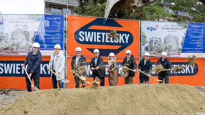 Personen mit Spaten vor der Baustelle