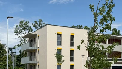 Wohnhaus mit Balkonen und Bäumen